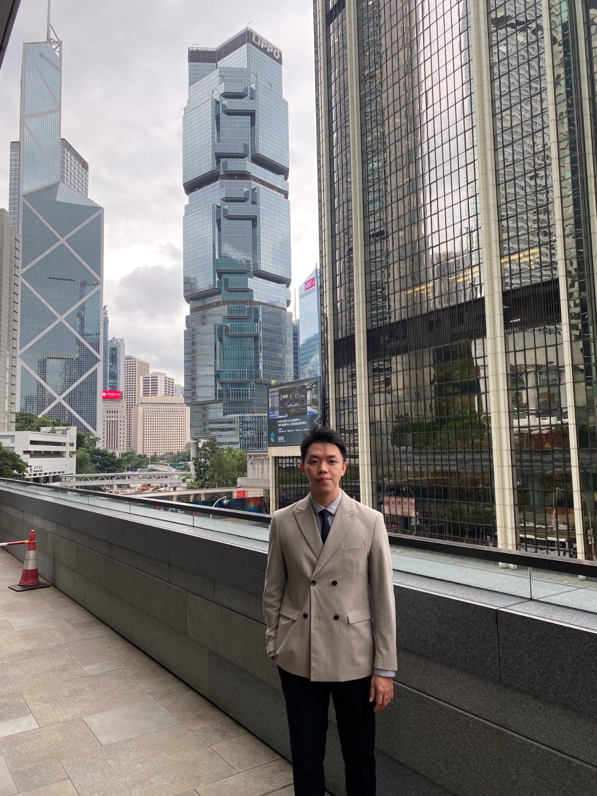 Chris Phương đứng trước các tòa tháp tài chính Hồng Kông, 2026